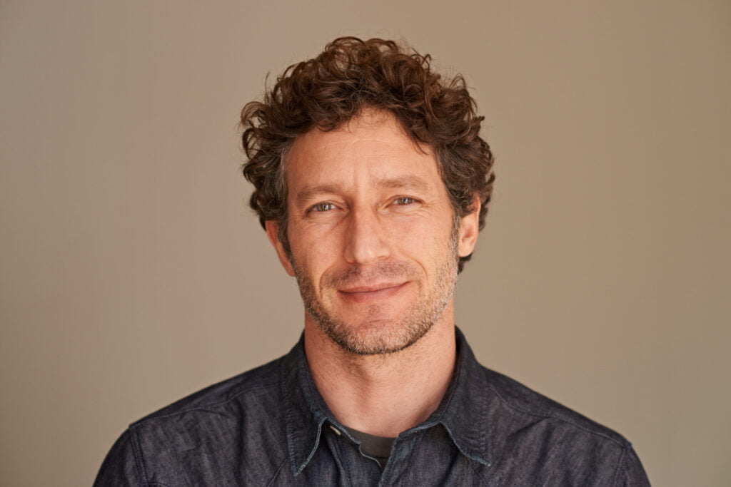 Handsome man smiling softly at camera in a studio